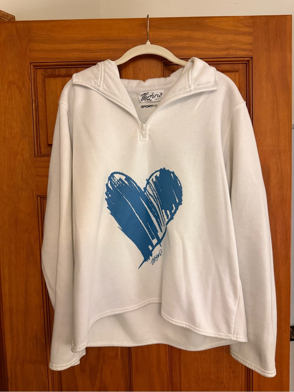 White quarter-zip pullover with blue heart